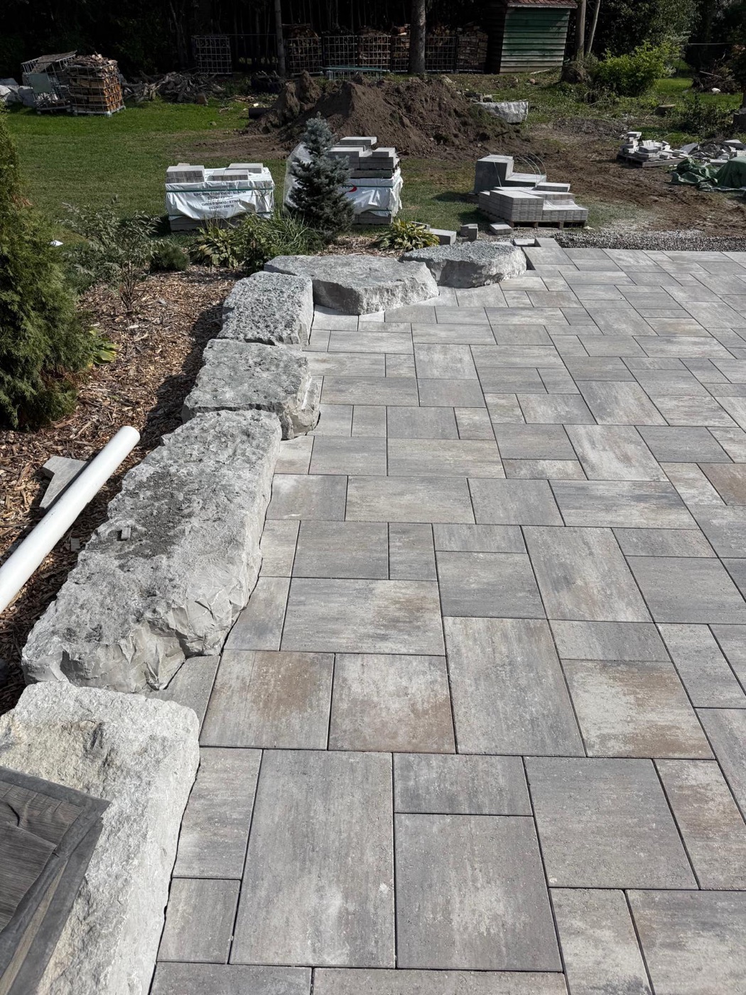 Large interlock patio installation with natural stone edge pieces